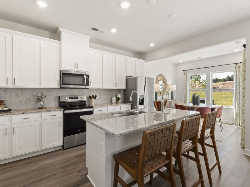 The well-appointed kitchen with a large island and generous pantry makes meal prep a breeze.