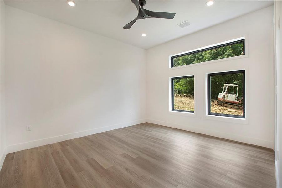 Empty room with ceiling fan and hardwood / wood-style flooring