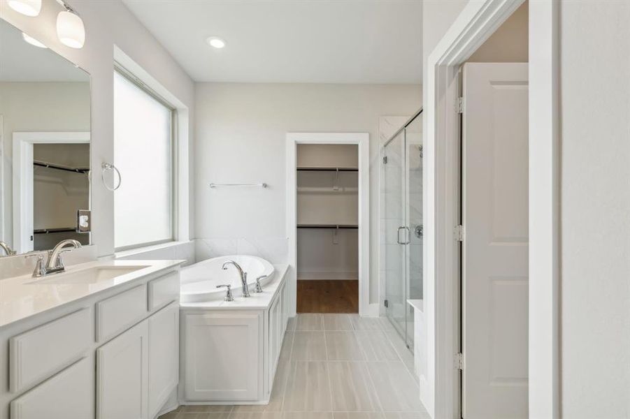 Bathroom featuring vanity, plus walk in shower, and tile patterned floors