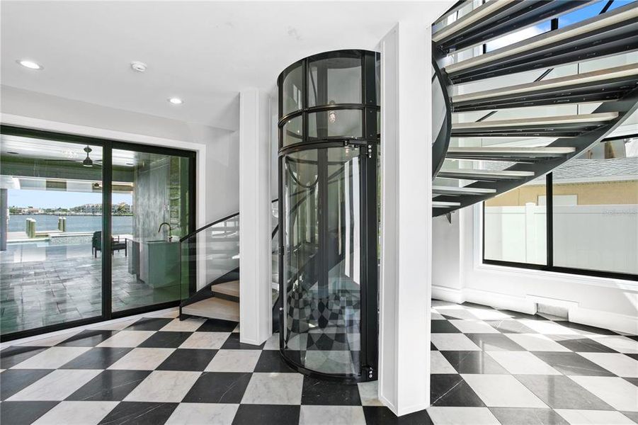 Stunning entrance with sweeping spiral staircase and circular elevator