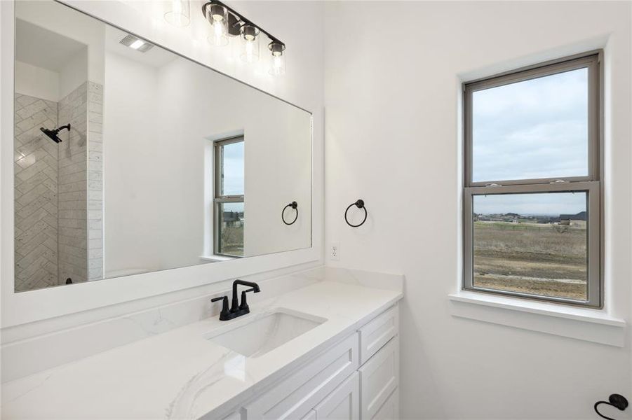 Bathroom with vanity and tiled shower