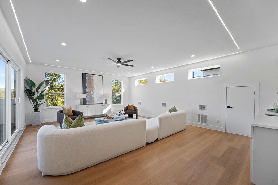 Living room with light hardwood / wood-style floors and ceiling fan