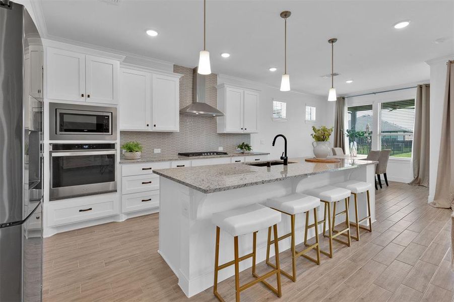 Beautiful white cabinetry with large island and stainless steel appliances.