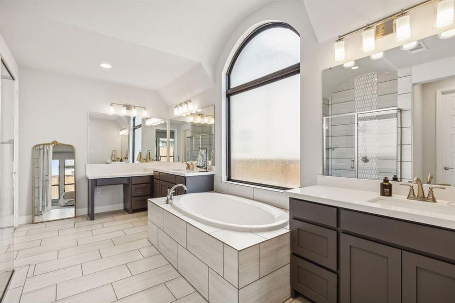 Bathroom with plus walk in shower, vaulted ceiling, and a healthy amount of sunlight