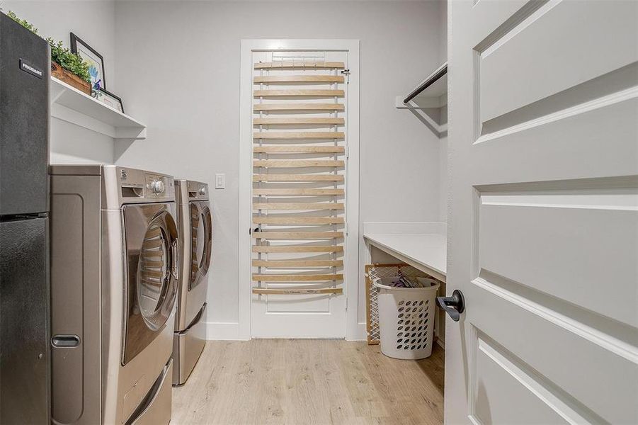 Clothes washing area featuring light hardwood / wood-style floors and separate washer and dryer