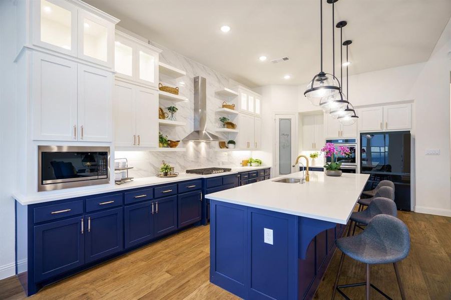 Kitchen featuring island exhaust hood, white cabinets, and blue cabinets