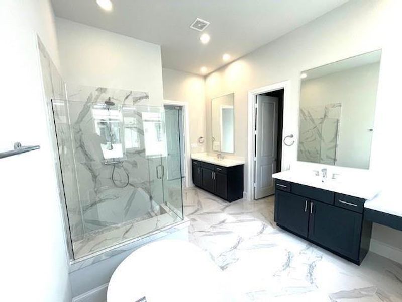 Primary bath shot…….(description) The most wonderful bathroom with separate vanities, large mirrors, freestanding tub, huge windows for extra light, and a very big shower with bench seating.