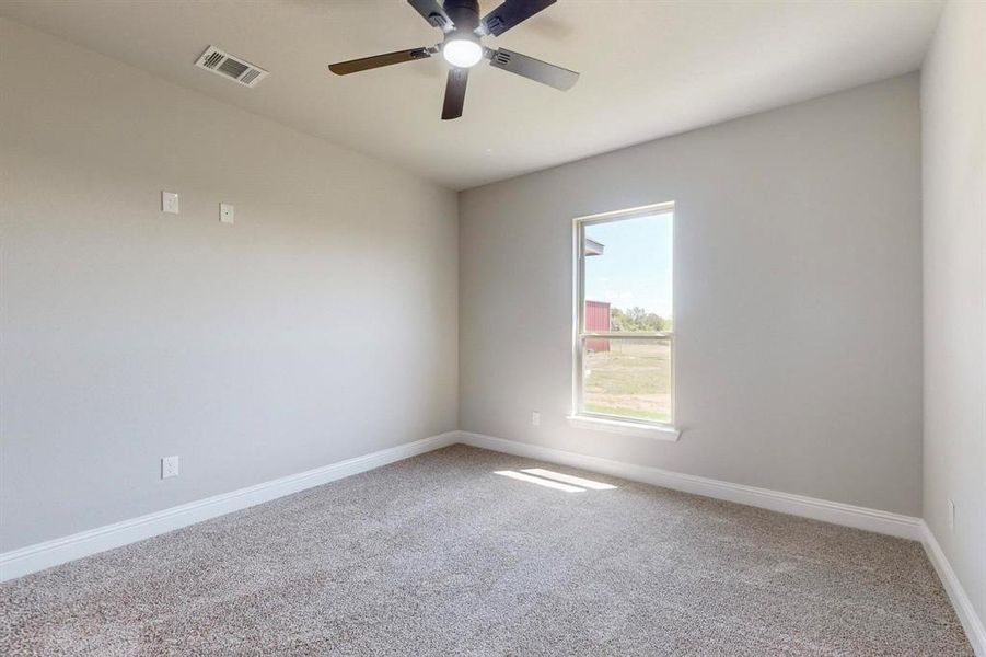 Carpeted empty room with ceiling fan