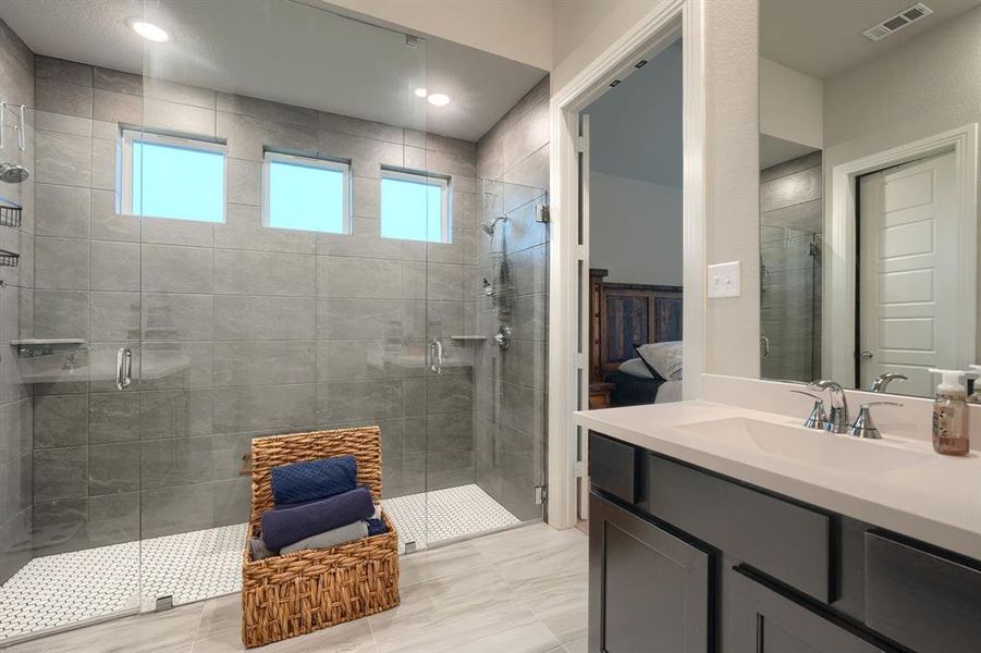 Bathroom with a shower with door, vanity, and tile patterned floors