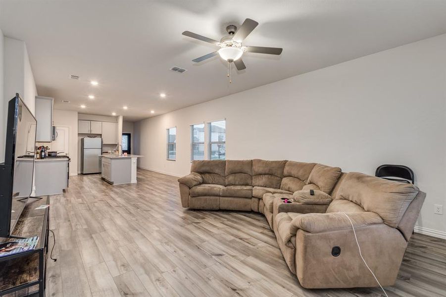 Living room featuring ceiling fan and light hardwood / wood-style flooring