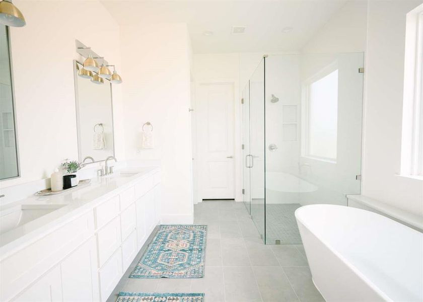 Bathroom featuring oversized vanity, double sink, tile floors, and plus walk in shower