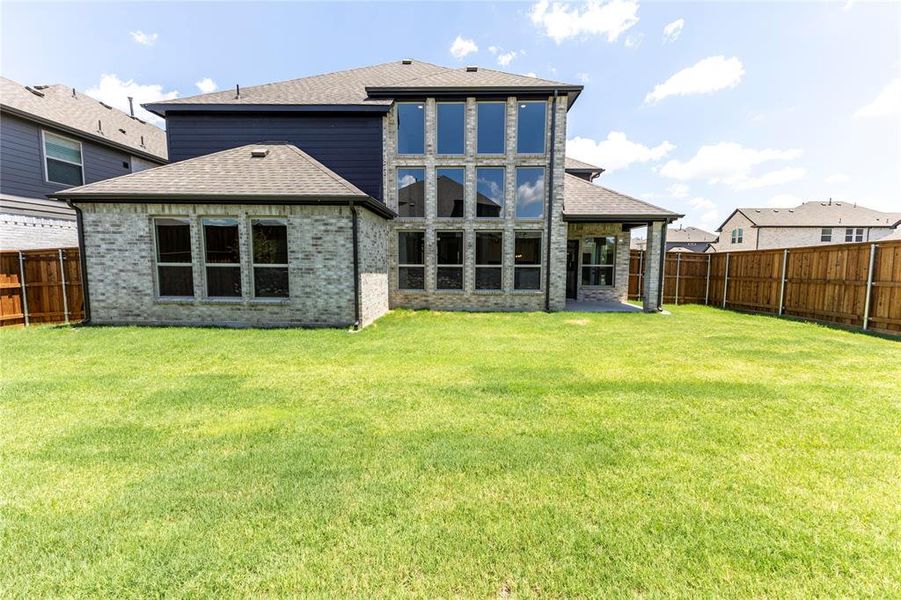 Back of property with a patio and a lawn