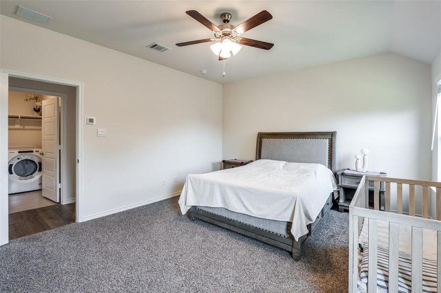 Bedroom with washer / clothes dryer, ceiling fan, a spacious closet, vaulted ceiling, and a closet