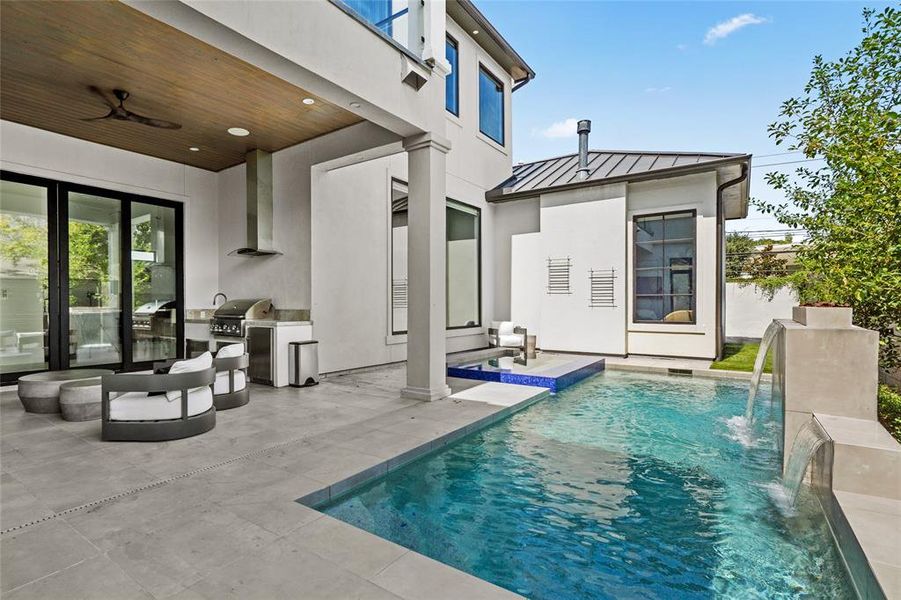 This stunning backyard oasis features a sparkling pool with a connected spa, offering the perfect place to relax and unwind. Adjacent to the pool, the covered patio with summer kitchen seamlessly blends indoor and outdoor living spaces, while the safety fence around the pool provides peace of mind for families.