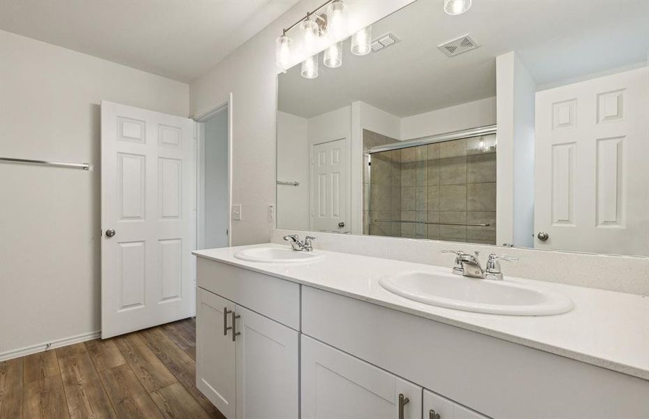 Dual vanity and oversized shower in owner's suite  *real home pictured