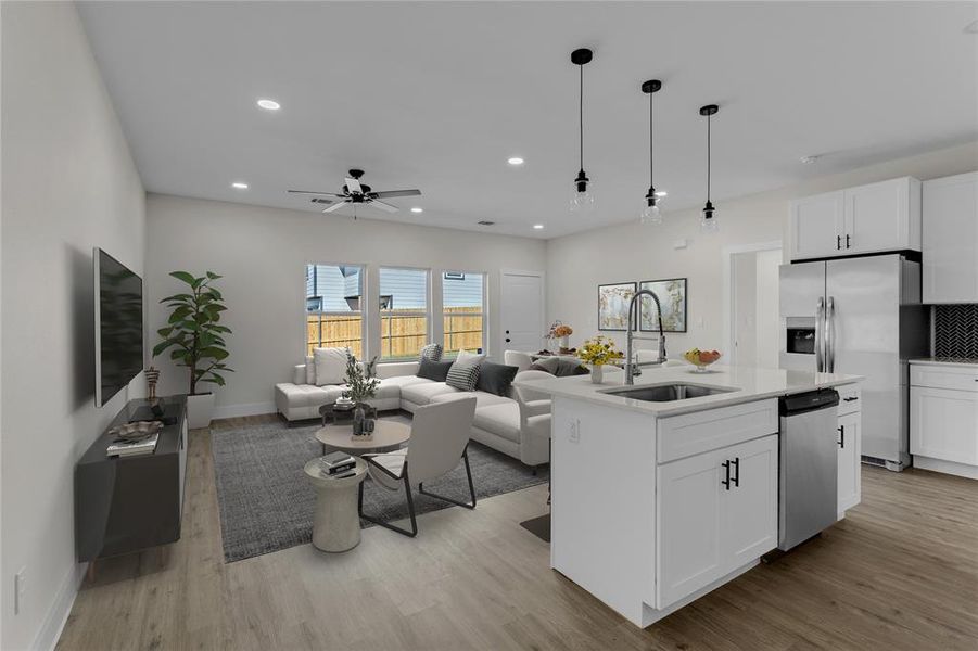 Kitchen with stainless steel appliances, white cabinetry, a center island with sink, and sink