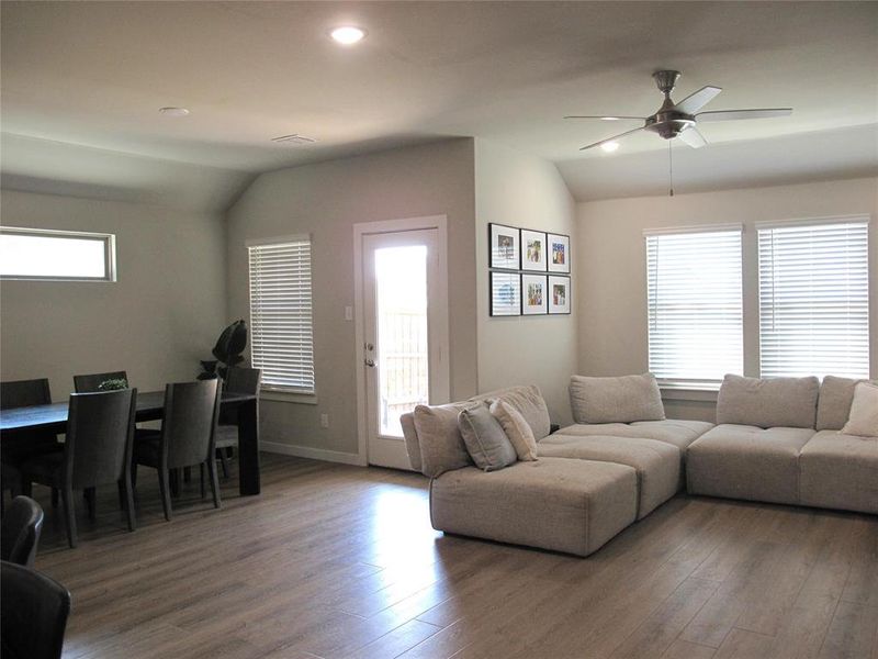 Living room featuring vaulted ceiling, a wealth of natural light, and hardwood / wood-style floors