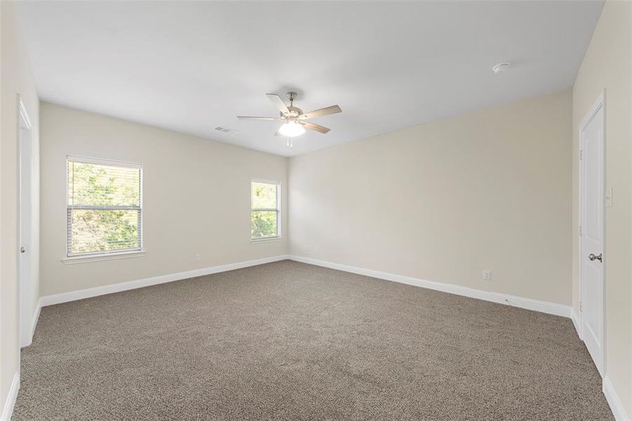 Carpeted empty room with ceiling fan