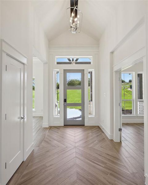 Entryway featuring lofted ceiling and a notable chandelier