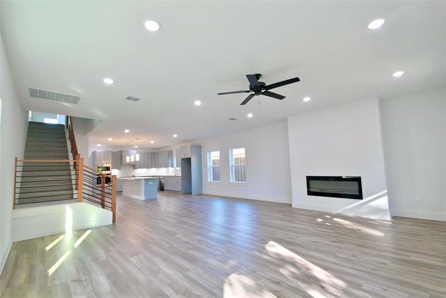 Unfurnished living room with ceiling fan and light hardwood / wood-style floors