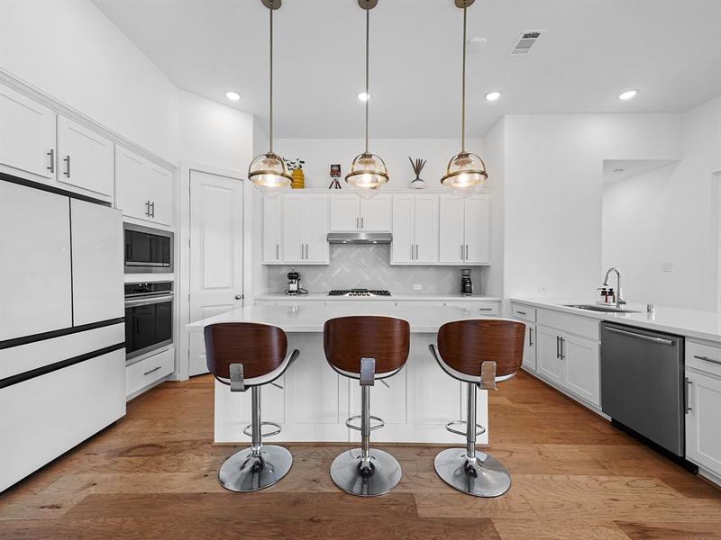 Welcome to your dream kitchen! This stunning island kitchen features sleek white cabinets that perfectly complement the elegant quartz countertops. The gray decorative tile backsplash adds a contemporary touch, while the stainless steel appliances provide both style and functionality.