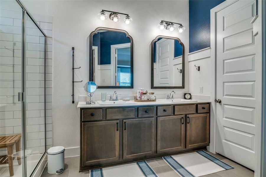 Bathroom featuring vanity, tile patterned flooring, and a shower with door