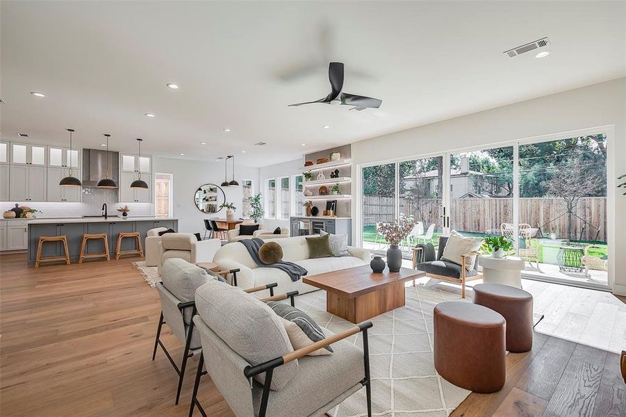 Living room with ceiling fan, light hardwood / wood-style flooring, and sink