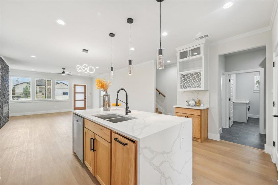 Kitchen featuring a center island with sink, light hardwood / wood-style flooring, stainless steel dishwasher, sink, and ceiling fan