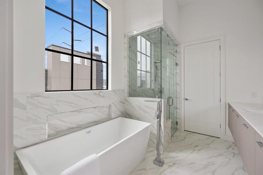 Indulge in the ultimate shower experience in the primary bathroom, featuring a master shower with both a showerhead and handheld option for your relaxation as well as an elegant freestanding tub, complete with a tub filler for the most luxurious baths.