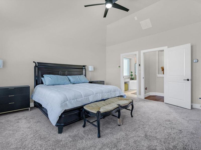 Bedroom featuring connected bathroom, carpet, high vaulted ceiling, and ceiling fan