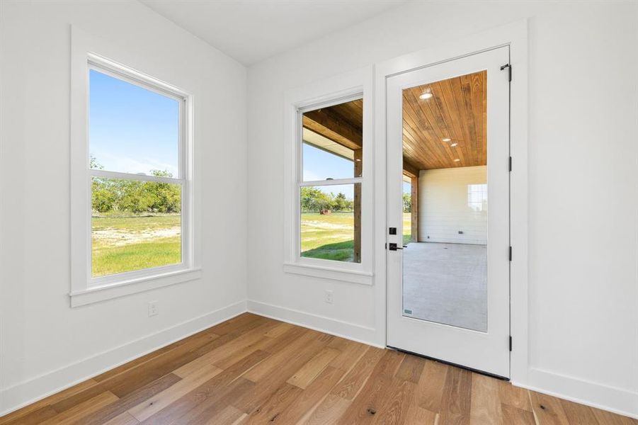 Doorway to outside with light hardwood / wood-style flooring and wood ceiling