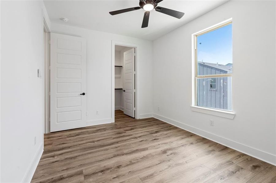 This upstairs third bedroom combines natural light from the window with ample closet space.