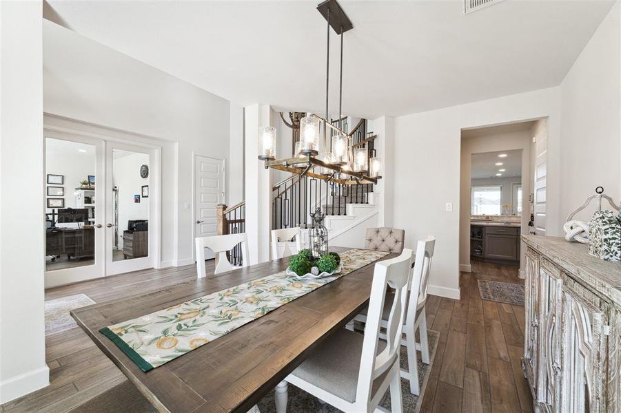 A view across the formal dining room toward the entry, office/study, stair case and butler pantry access.