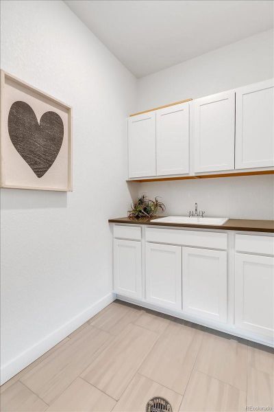 Full Laundry Room with ample Storage and Sink