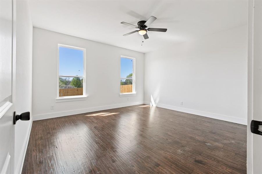 Spare room with dark hardwood / wood-style flooring and ceiling fan