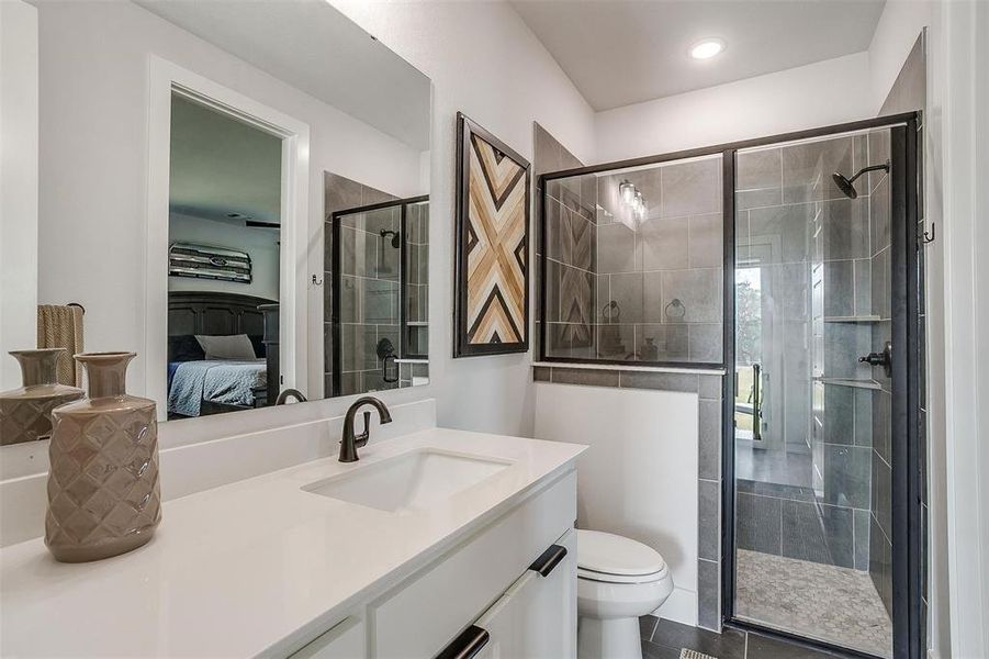 Bathroom with vanity, toilet, tile patterned floors, and walk in shower