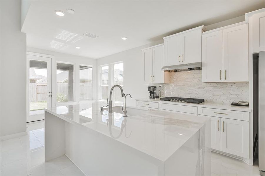 This is a modern, bright kitchen with white cabinetry, sleek countertops, and stainless steel appliances.