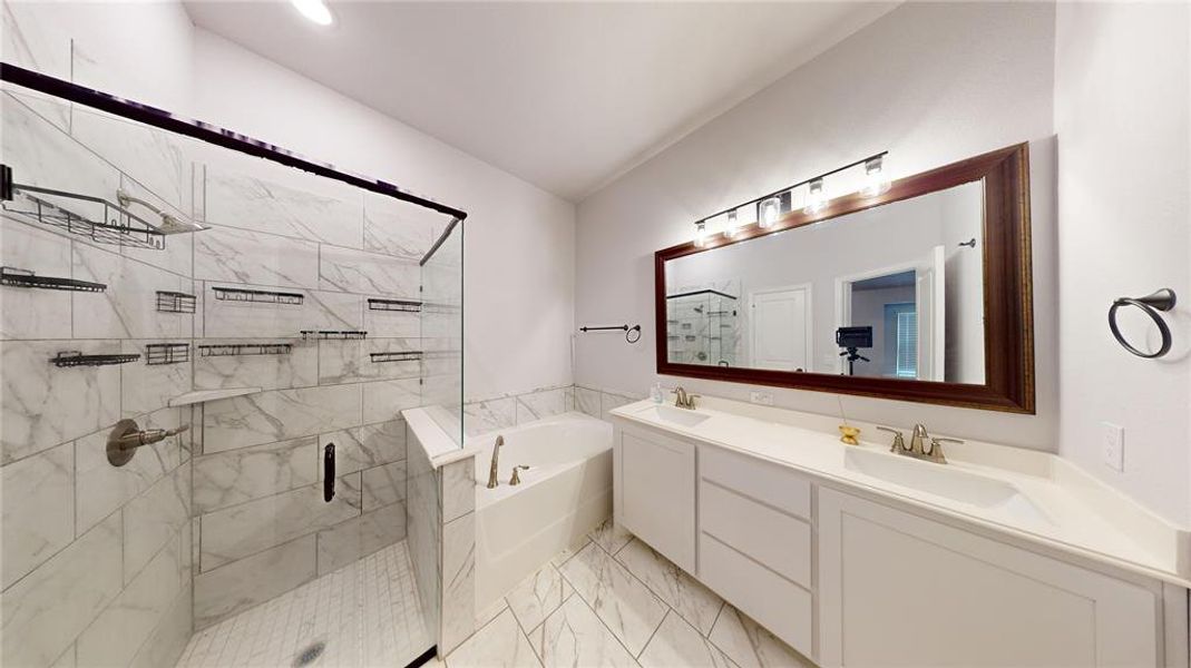 Bathroom featuring vanity, shower with separate bathtub, and lofted ceiling