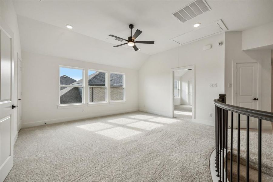 Carpeted empty room with vaulted ceiling and ceiling fan