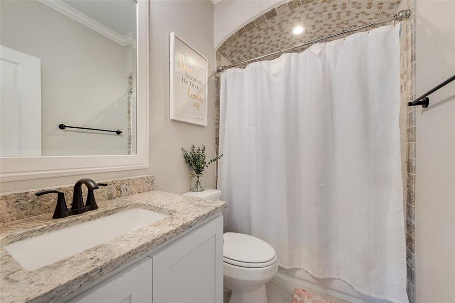 Bathroom featuring vanity, crown molding, and toilet