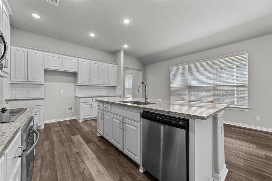 Kitchen with dishwasher, sink, and white cabinetry