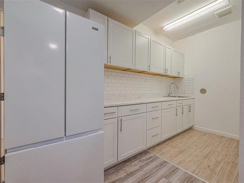 This kitchen boasts clean lines, ample counter space, and stainless steel appliances for a sleek and modern look.