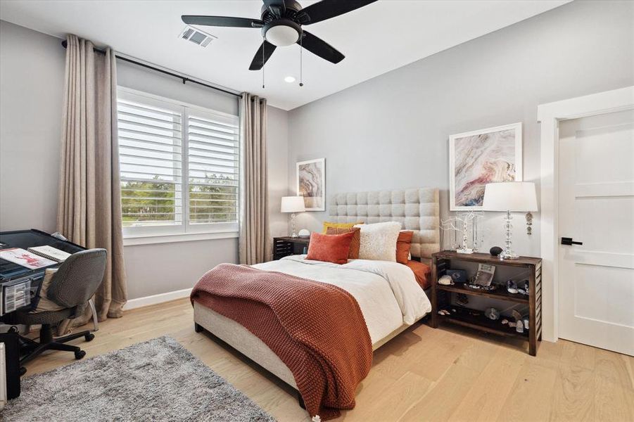 Secondary bedroom with engineered wood floors, recessed lighting, ceiling fan with a light, plantation shutters and is en suite.
