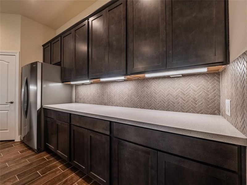 has this great long granite counter top and the beautiful back splash extends around the kitchen with cabinets and under cabinet lighting