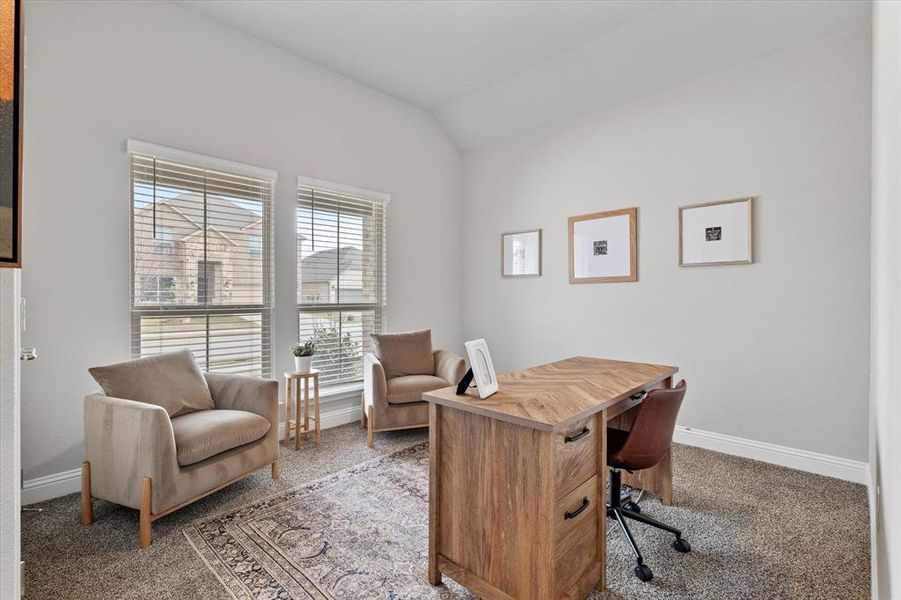 Office space with lofted ceiling and carpet floors