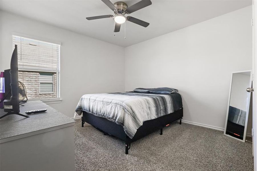 Bedroom with ceiling fan and dark carpet