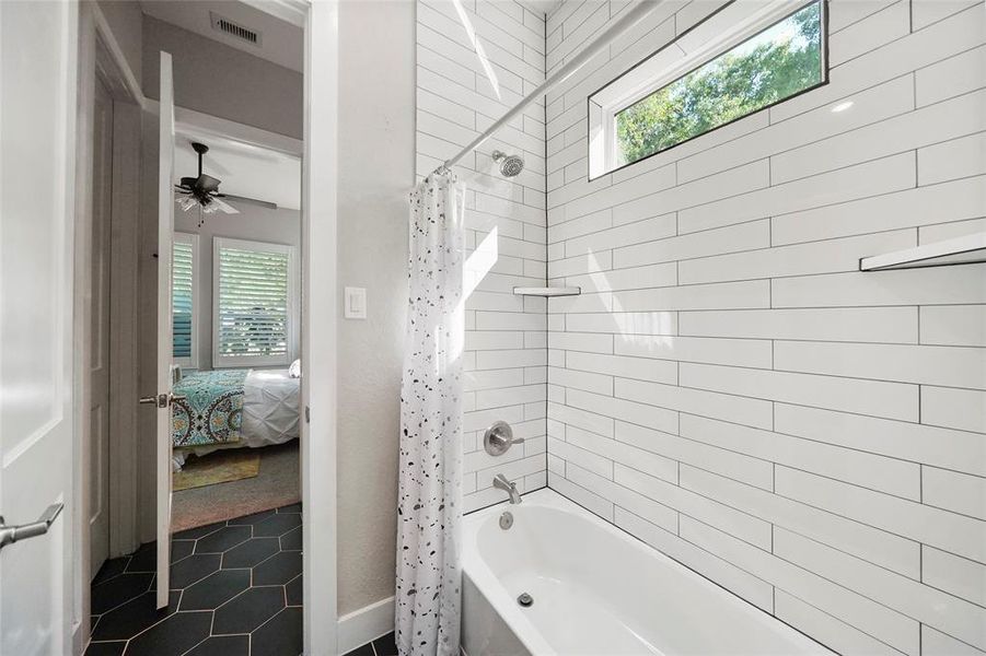 A beautifully updated Hollywood bathroom separates two of the first-floor guest suites. Each suite has a private dressing area with a single sink vanity with a shared water closet in between.
