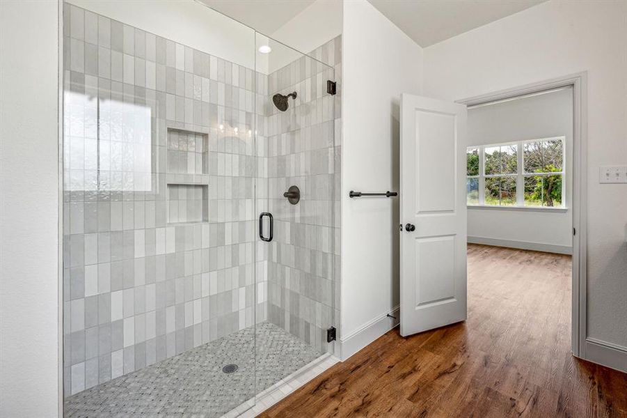 Bathroom with a shower with shower door and hardwood / wood-style flooring