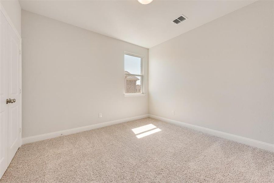 Spare room featuring carpet and vaulted ceiling