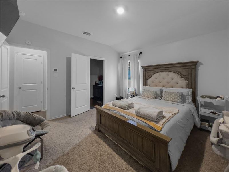 Bedroom with vaulted ceiling and light colored carpet